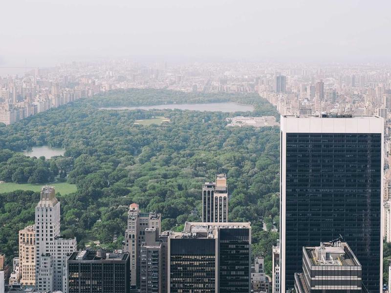 Aerial view of Central Park surrounded by Manhattan skyscrapers on a hazy day
